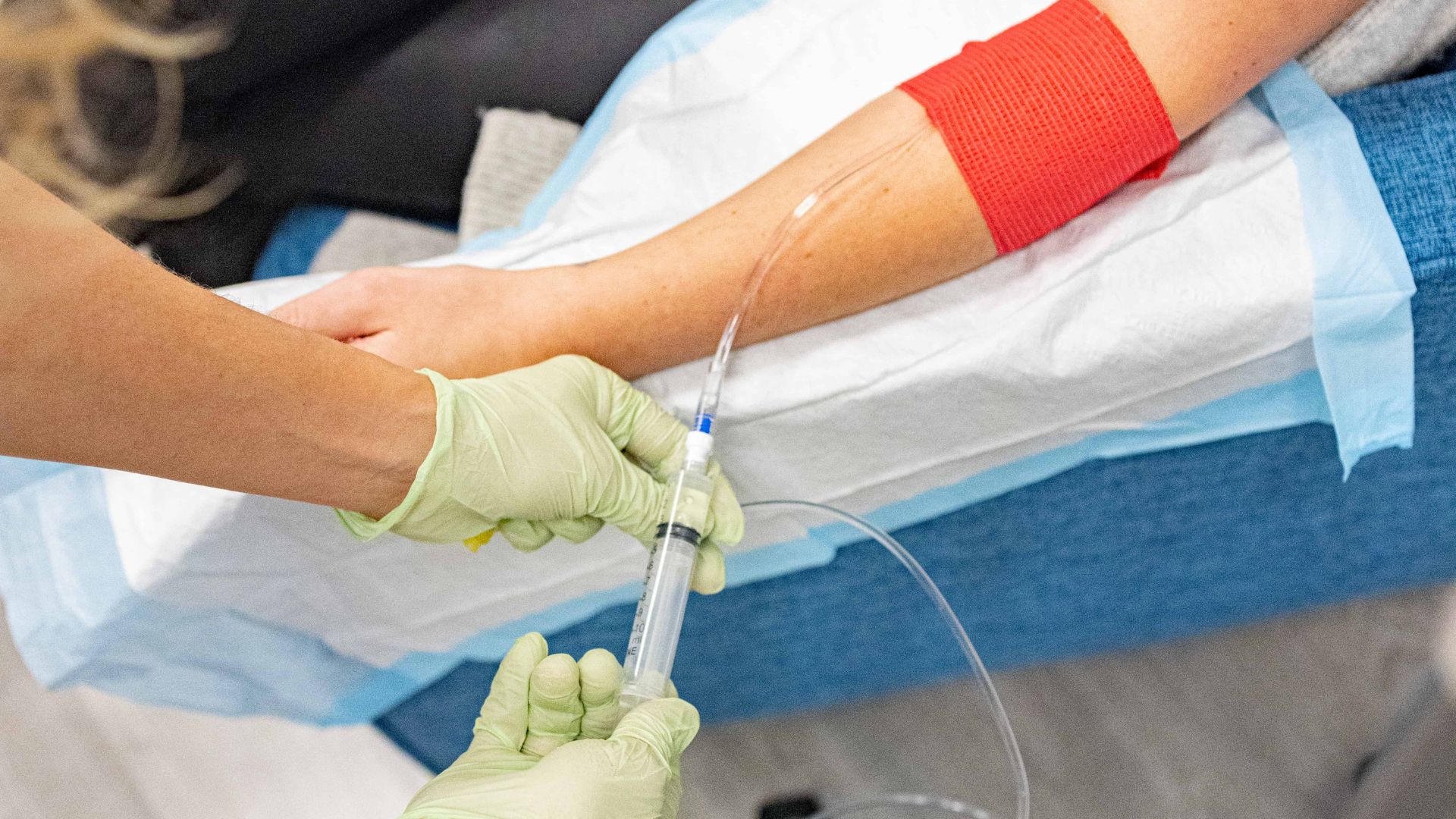 Healthcare professional administering IV into patient