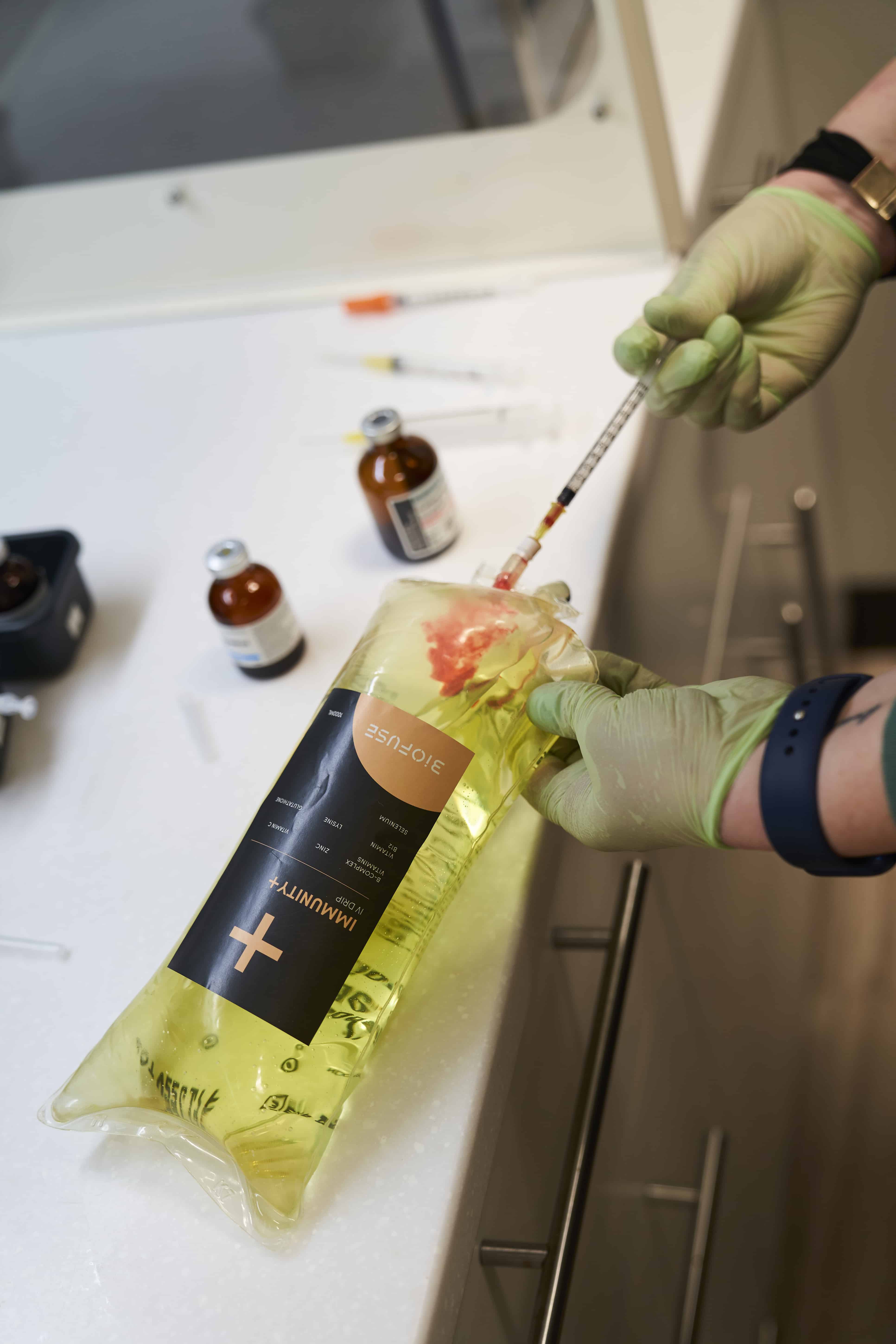 Healthcare professional in gloves preparing a vitamin injection at Biofuse Wellness Center