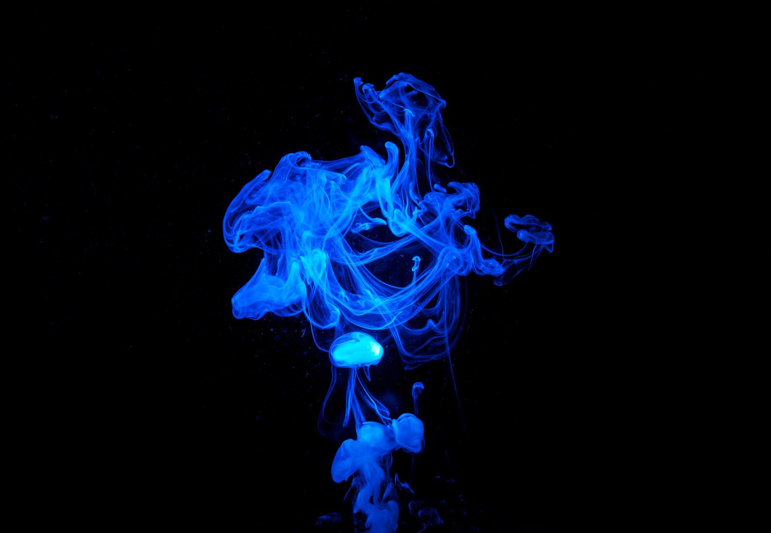 Vivid blue ink cloud dispersing in dark water, abstract.Methylene Blue.